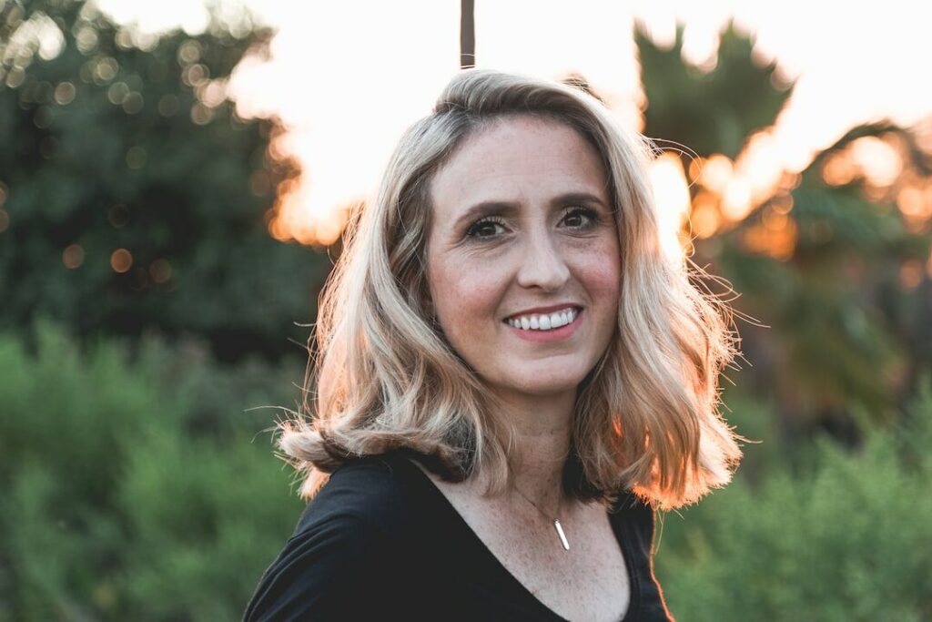 Frau lächelt im Sonnenunterganglicht.